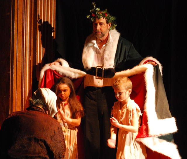 GHOST OF CHRISTMAS PRESENT with WANT and IGNORANCE -- "Are there no workhouse?"